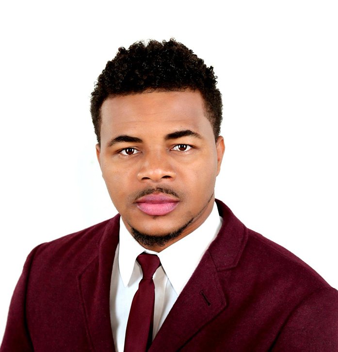 Photo of the Founder, Jn Kedson. In a red suit.